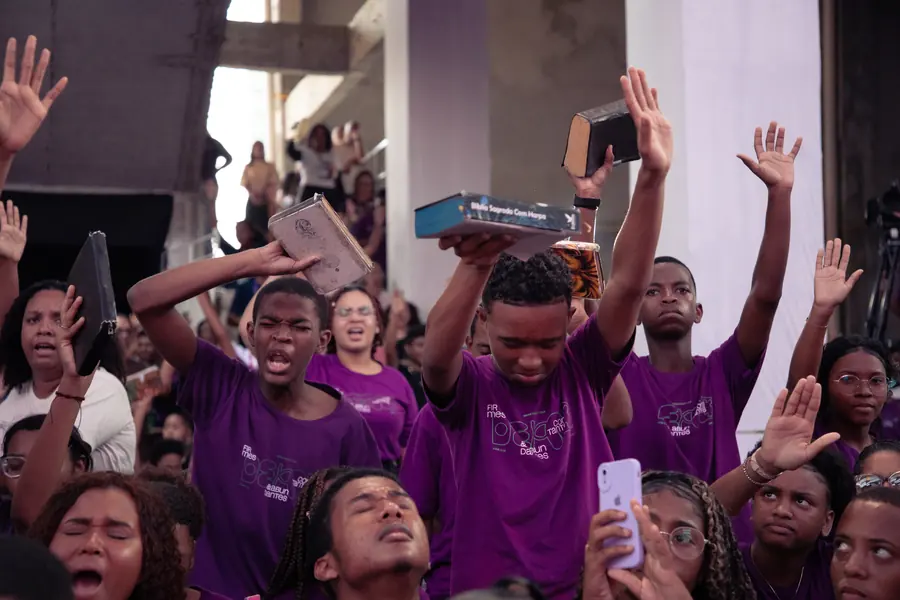 Adolescentes erguendo suas Bíblias durante a ministração